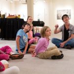 Family workshop participants learn about artwork in the exhibition Threatening Beauty